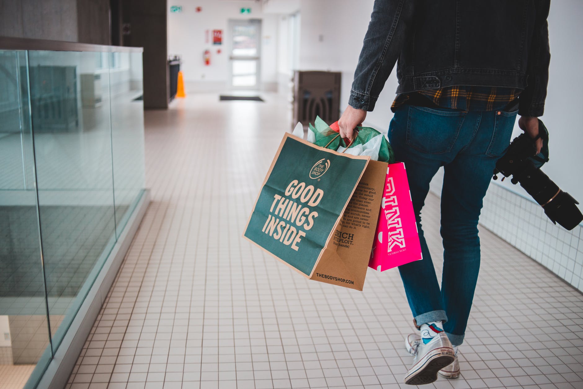 person holding shopping bags and camera
