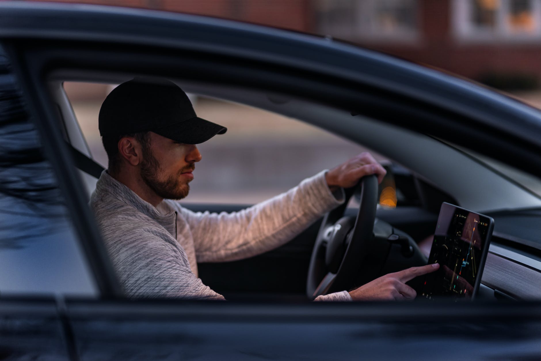 man in gray long sleeve shirt driving a car