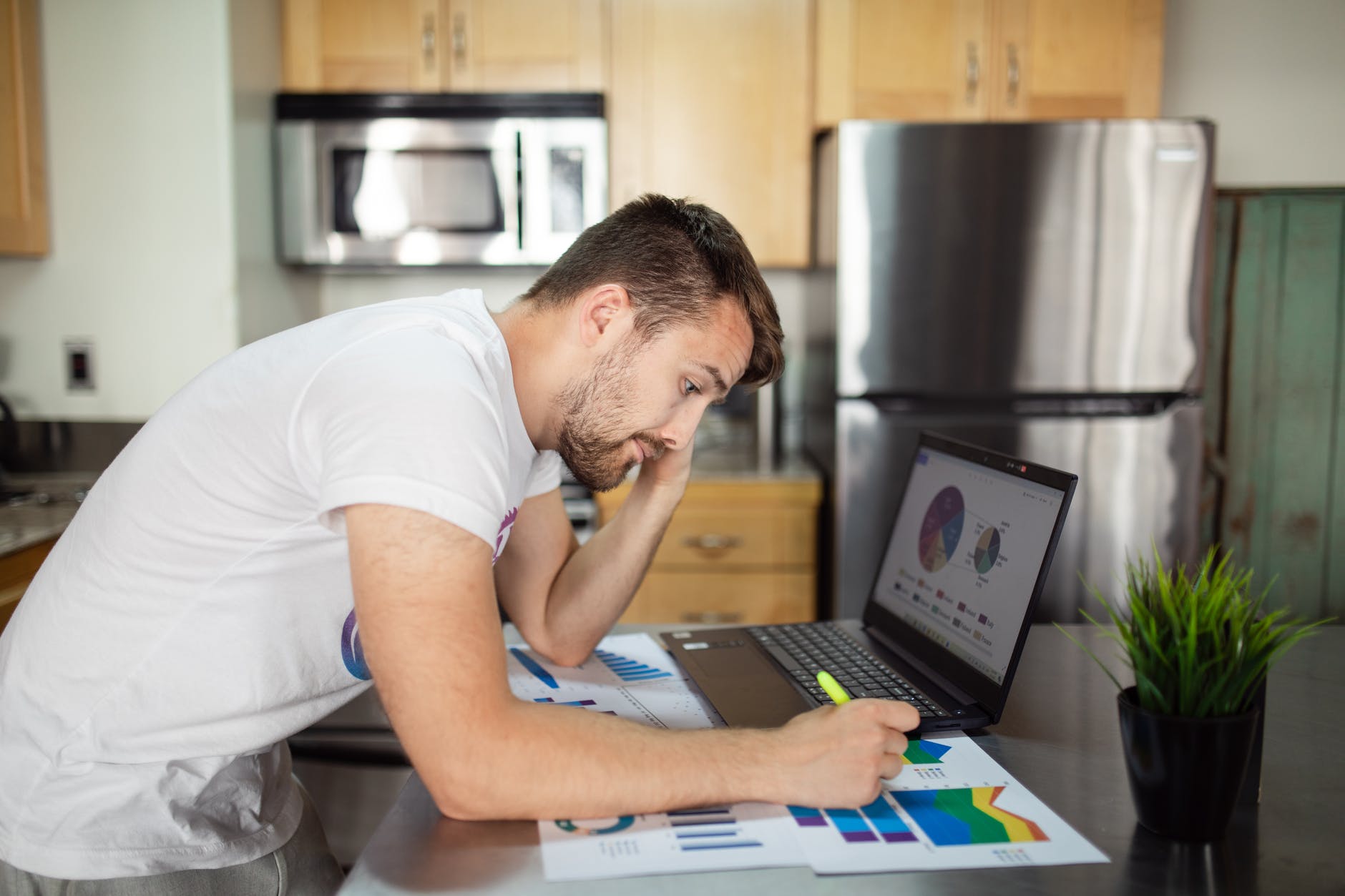 man in white t shirt using laptop computer